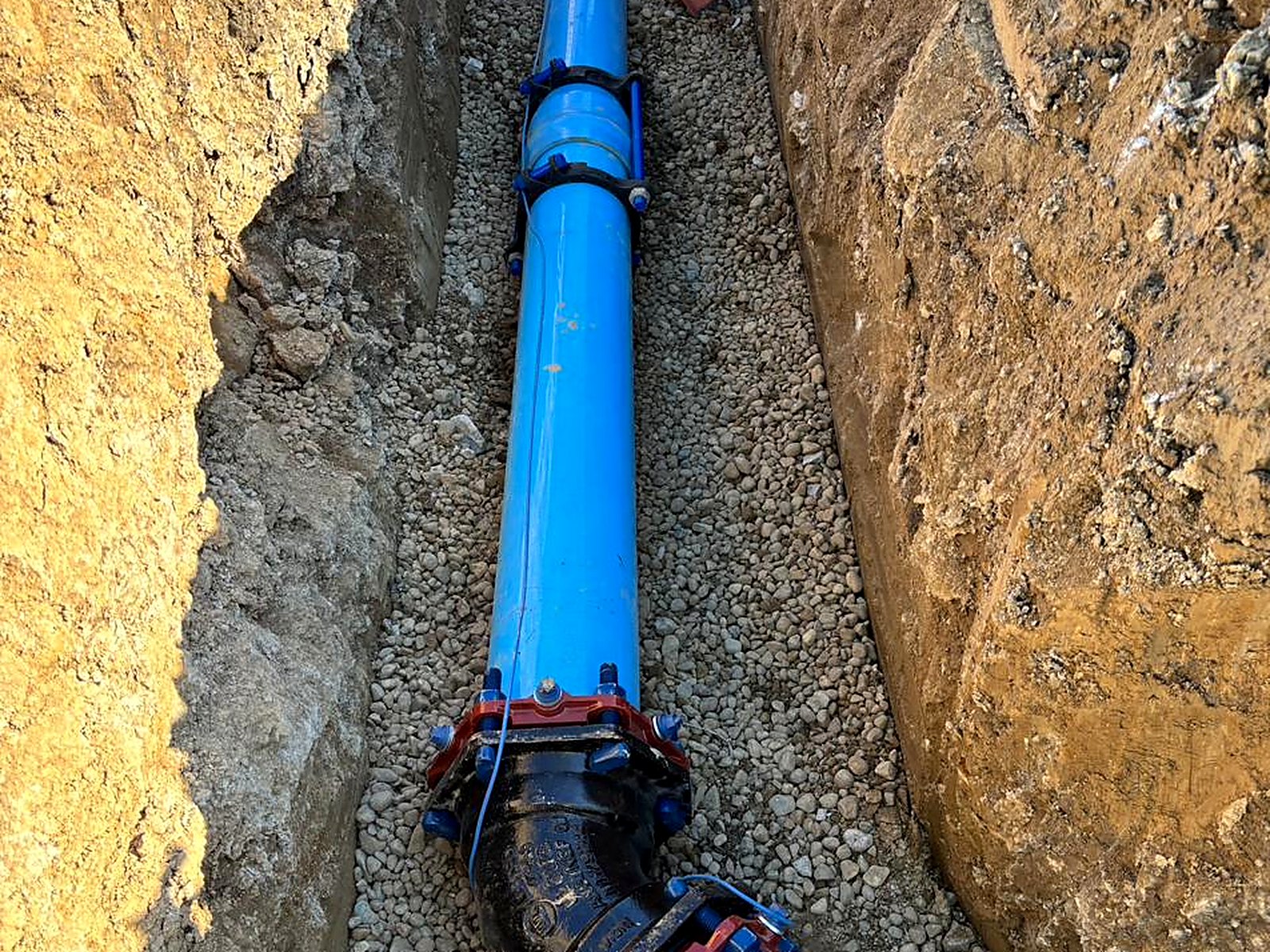 C900 water main with restrained fittings installed in an open trench